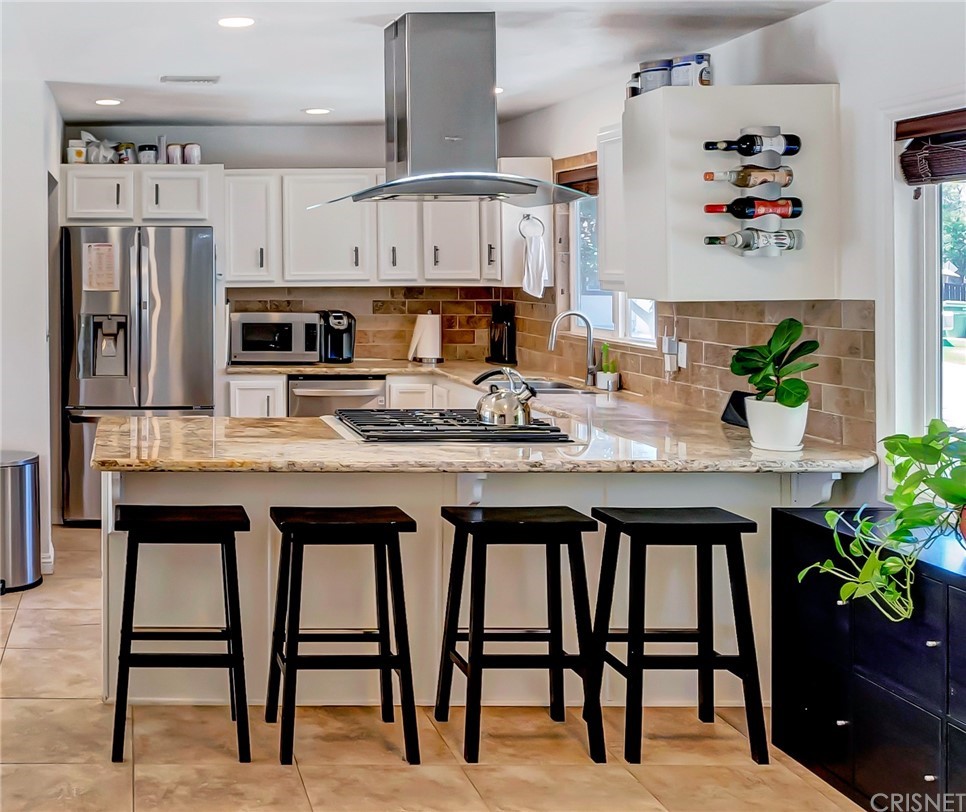 6720 Kurl Way Reseda, CA 91335 - Photo 8 of 40 a kitchen with stainless steel appliances granite countertop a table chairs sink and cabinets