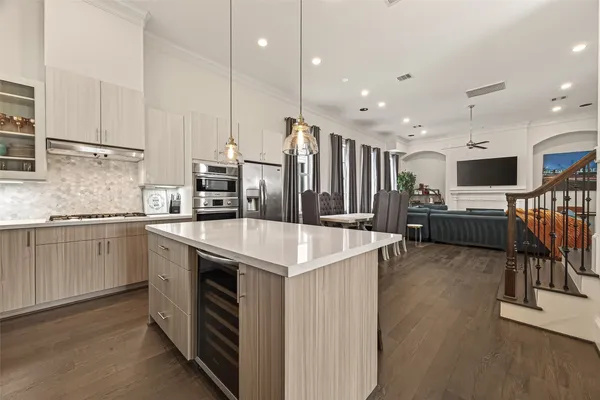 a kitchen with stainless steel appliances kitchen island granite countertop a stove top oven a sink a dining table and chairs