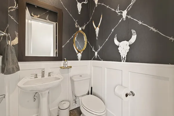 a bathroom with a toilet sink and mirror