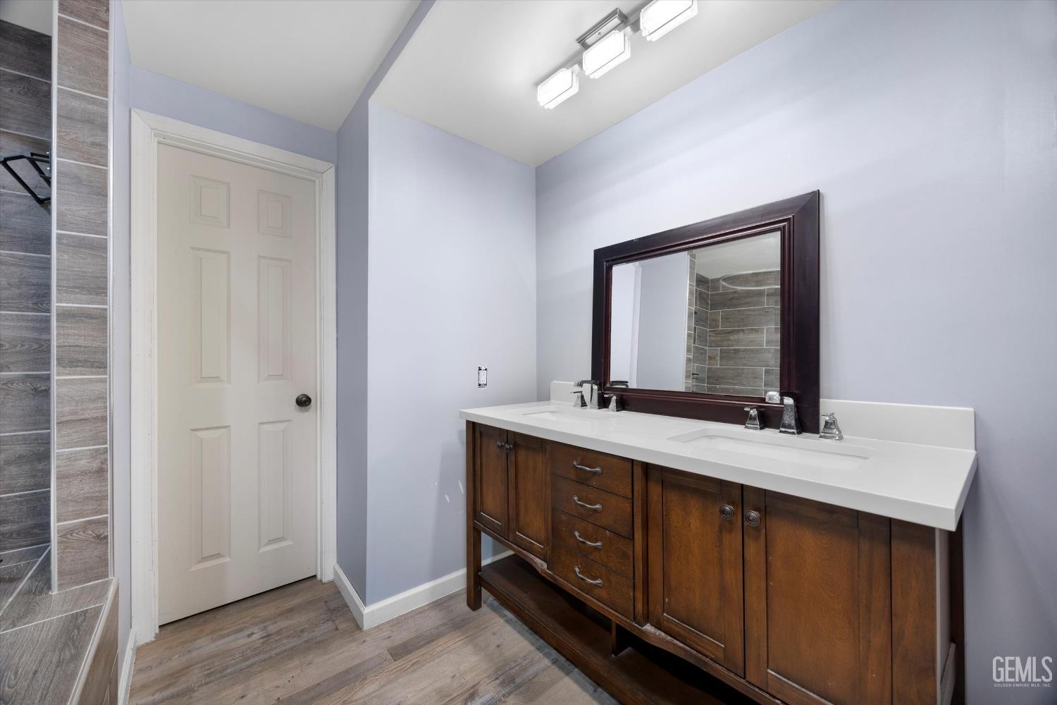 Undisclosed Address Bakersfield, CA 93305 - Photo 17 of 33 a bathroom with a double vanity sink and a mirror