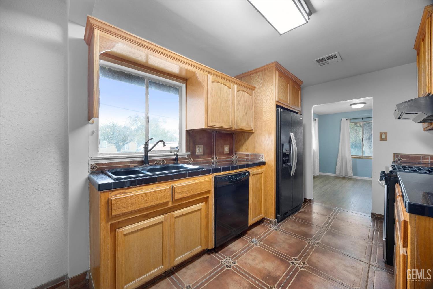 Undisclosed Address Bakersfield, CA 93305 - Photo 8 of 33 a kitchen with stainless steel appliances granite countertop a sink and a refrigerator