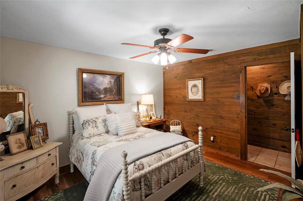 1516 Rancho Road Quinlan, TX 75474 - Photo 22 of 40 a bedroom with a bed and a chandelier