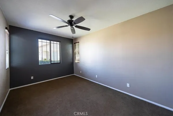 an empty room with a window and a fan
