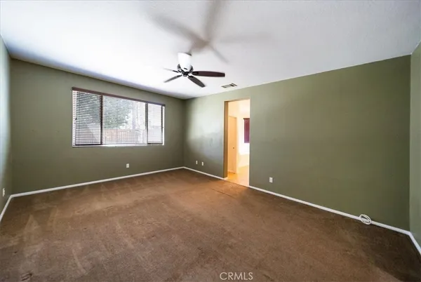 a view of a room with a ceiling fan and window