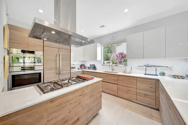 a kitchen with stainless steel appliances kitchen island granite countertop a sink stove and cabinets