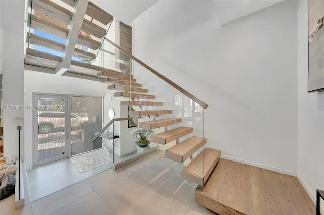 a view of entryway and hall with wooden floor and windows
