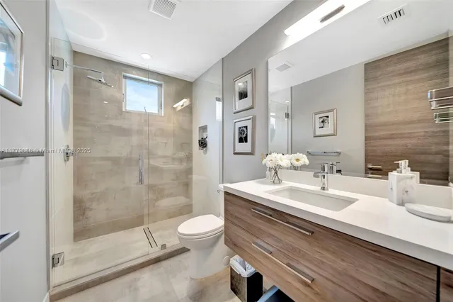 a bathroom with a double vanity sink toilet and shower