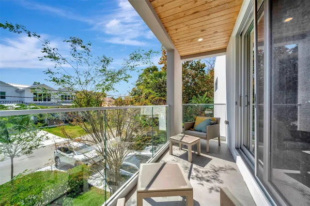 a view of a hallway with wooden floor and a living room