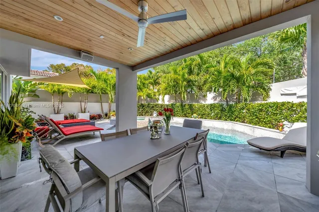 a view of yard from deck with patio