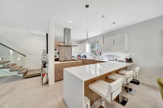 a large white kitchen with a table and chairs