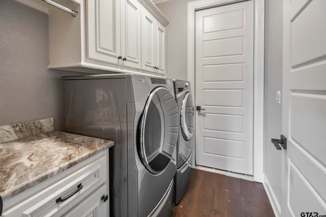 a utility room with granite countertop washer and dryer