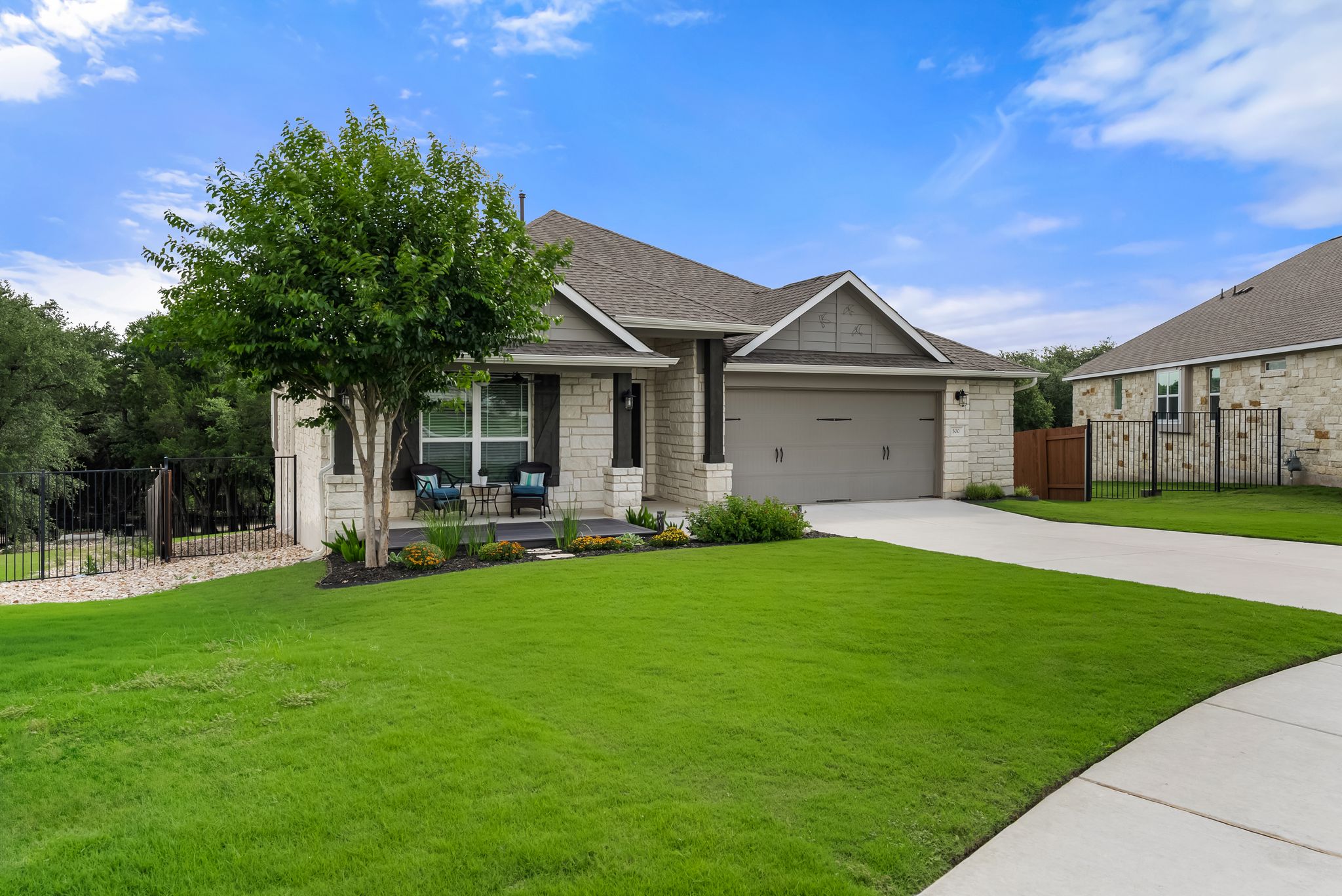 300 Prato Place Georgetown, TX 78628 - Photo 3 of 40 A welcoming stone and siding facade with a neat lawn and driveway leads to a covered entry.