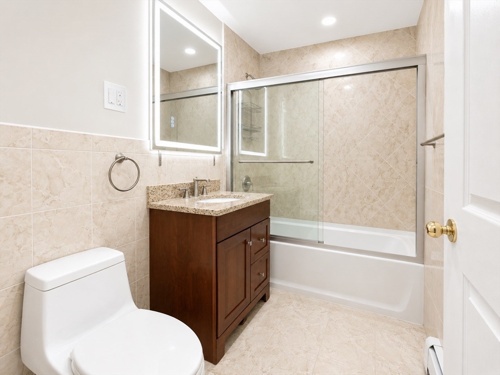 383 Langley Road, Unit 11 Newton, MA 02459 - Photo 8 of 15 a bathroom with a granite countertop sink toilet and shower