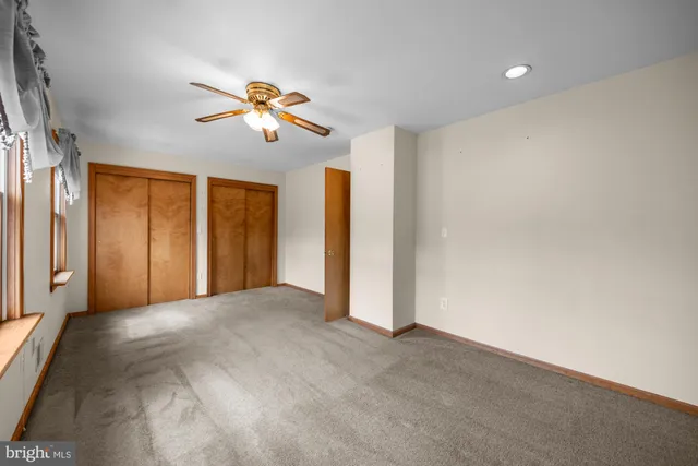 a view of a room with a ceiling fan and a window