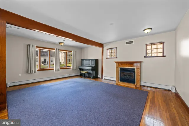 a view of empty room with fireplace and wooden floor