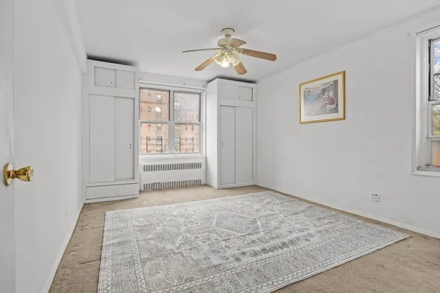 a spacious bedroom with a bed and a flat screen tv