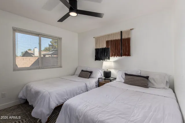 a bedroom with two bed and a flat screen tv