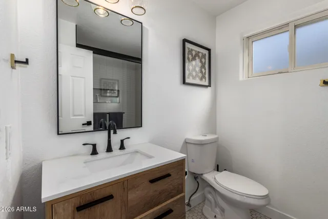 a bathroom with a toilet a sink and mirror