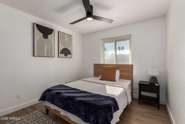 a bedroom with a bed and painting on the wall