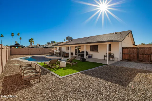 a view of a house with backyard and sitting area