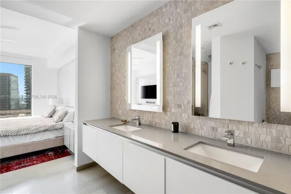 a bathroom with double vanity sinks and a mirror