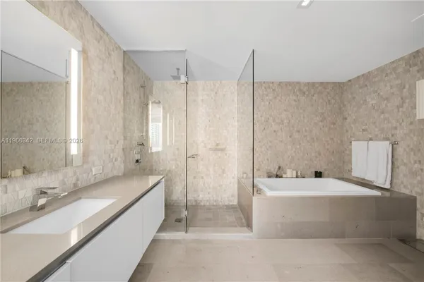 a bathroom with a large tub a sink a vanity and a shower