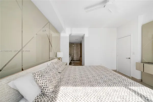 a bedroom with a large bed and a chandelier