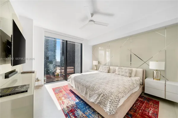 a bedroom with a bed a couch and large window