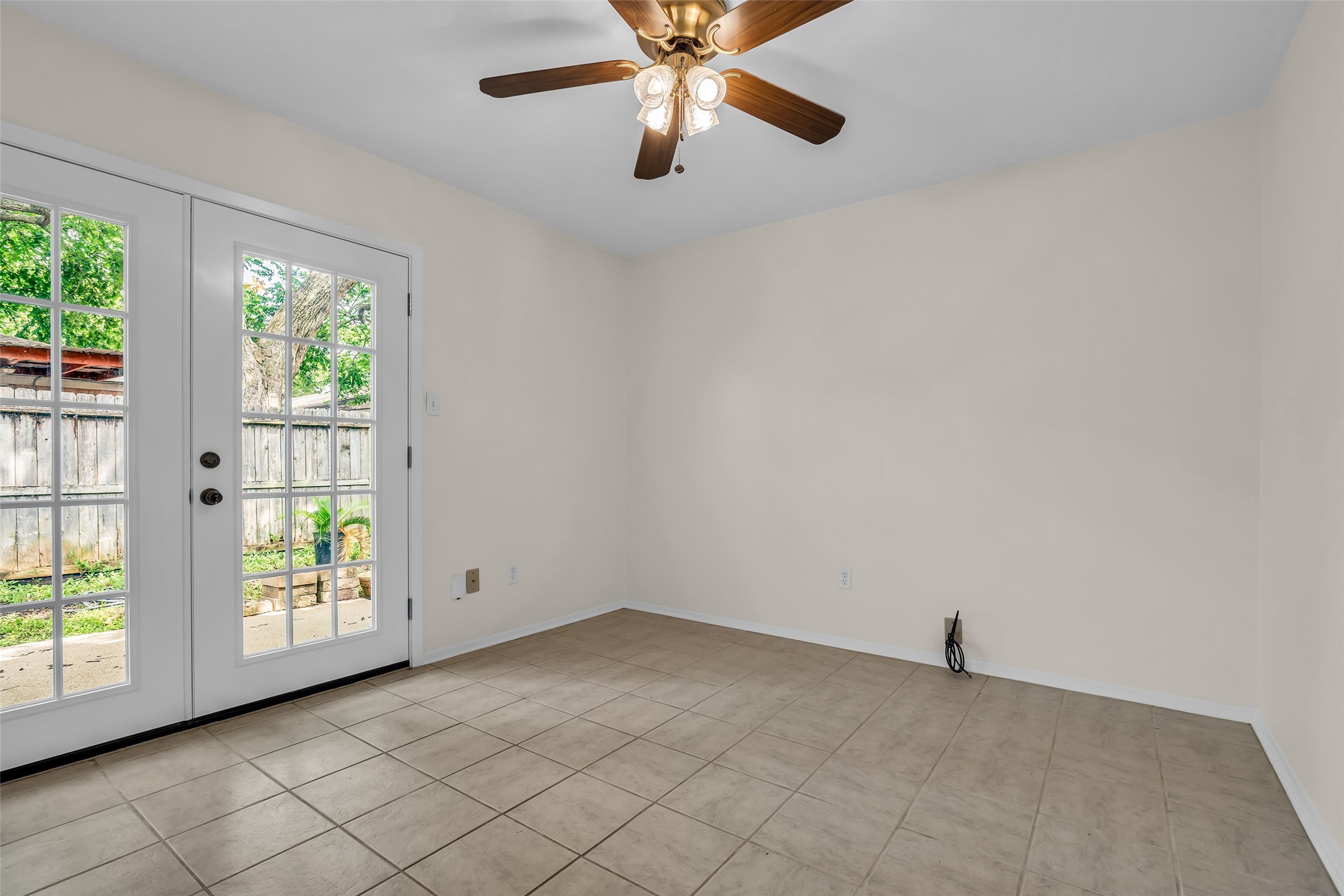 1447 Silverpines Road Houston, TX 77062 - Photo 15 of 17 Bright room with tiled floor, featuring large French doors leading to a fenced backyard. Ceiling fan adds comfort, making it a versatile space for a 2nd bedroom, dedicated office, nursery or hobby room. The possibilities are endless with this room