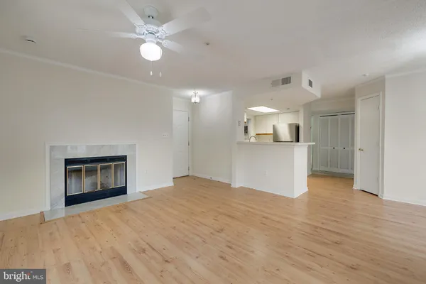 an empty room with windows and fireplace