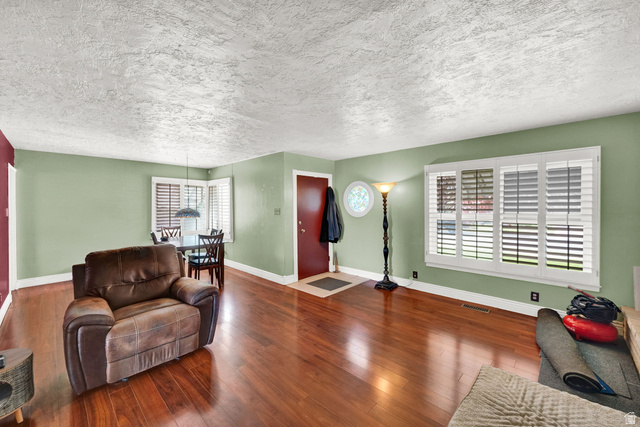 4635 Box Elder Street Murray, UT 84107 - Photo 5 of 21 Living room featuring a textured ceiling and dark wood-style floors