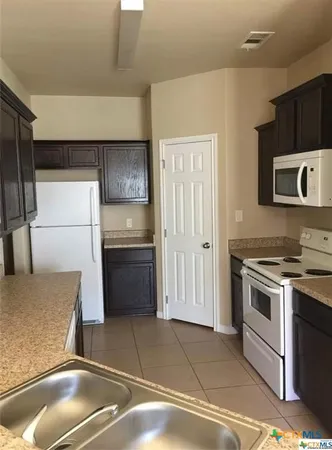 a kitchen with a stove and a refrigerator