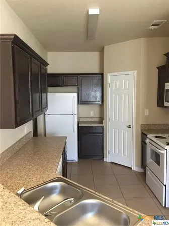 a kitchen with a refrigerator sink and stove