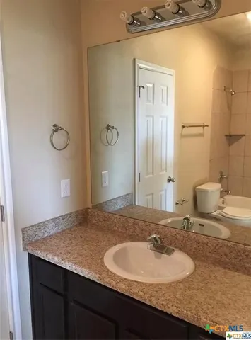 a bathroom with a granite countertop sink and a mirror