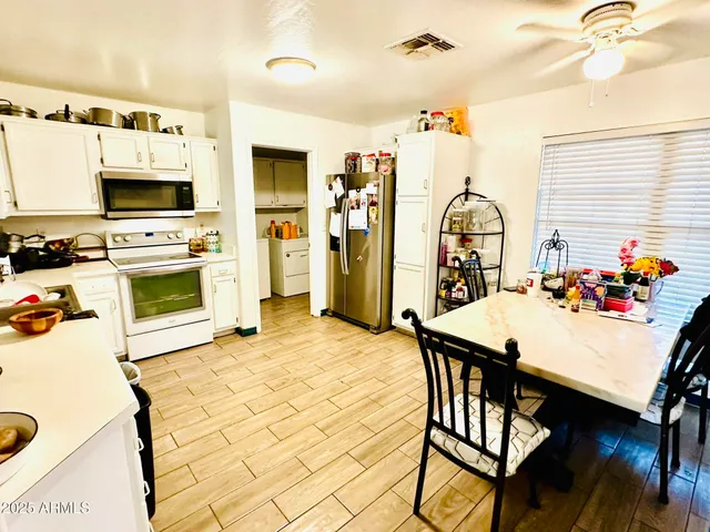 a kitchen with stainless steel appliances kitchen island granite countertop a stove a sink dishwasher and a refrigerator with wooden floor