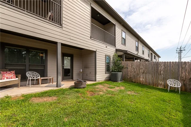 a view of a chair and table in backyard of the house