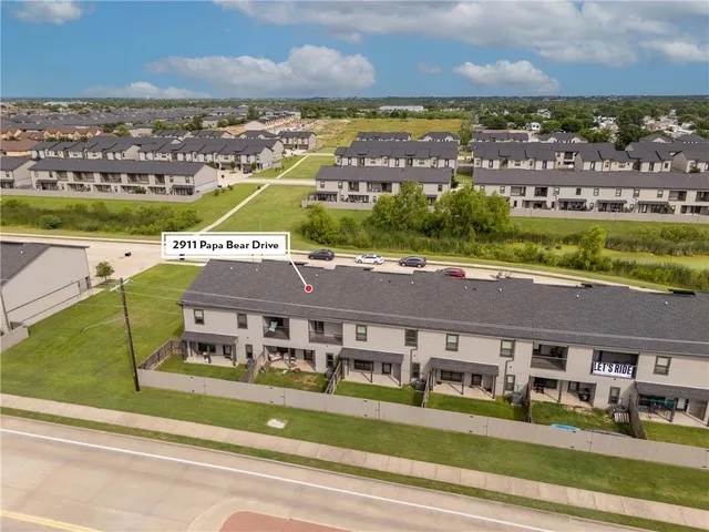 an aerial view of residential houses with outdoor space and ocean view