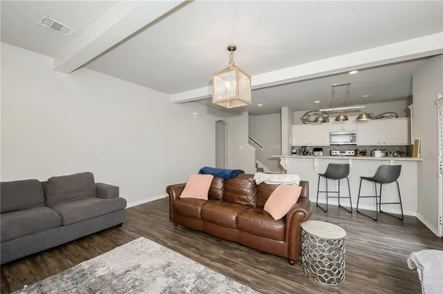 a living room with furniture a chandelier and a dining table