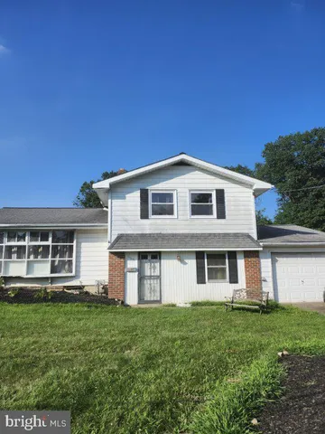 a view of a house with yard and sitting area