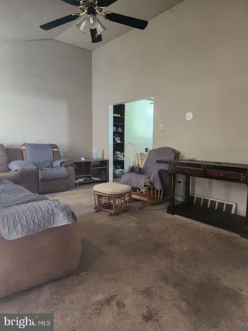 a living room with furniture and a ceiling fan