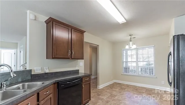 a kitchen with granite countertop stainless steel appliances a sink stove and cabinets