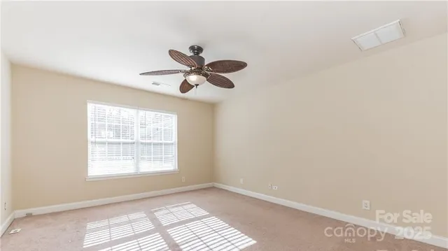 an empty room with windows and ceiling fan