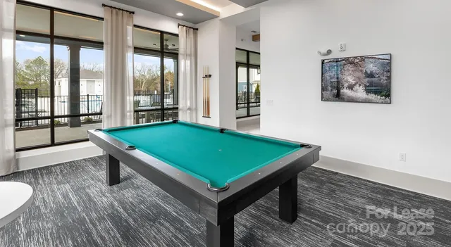 a room with pool table and windows