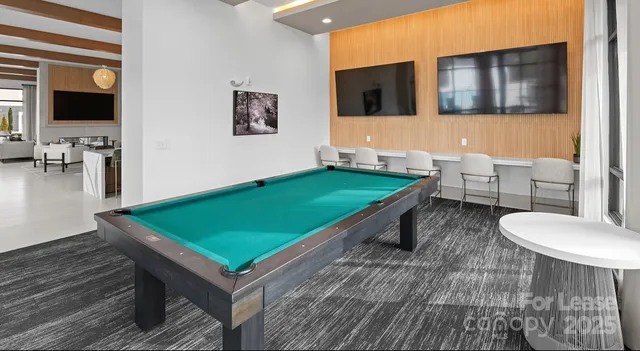 a room with chairs a table and a flat screen tv