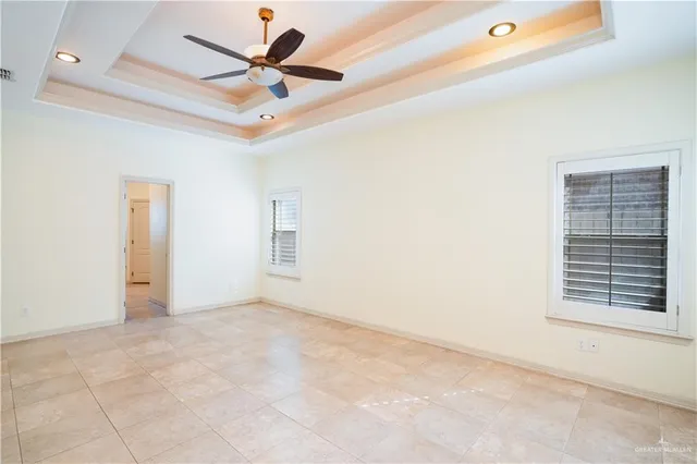 an empty room with windows and fan