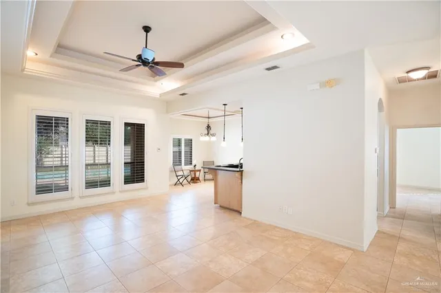 a view of a livingroom with a chandelier fan and windows