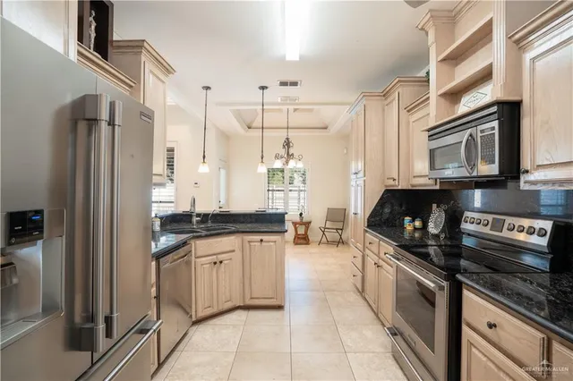 a kitchen with stainless steel appliances granite countertop a stove a sink and a microwave
