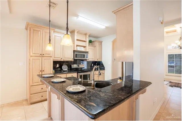 a kitchen with stainless steel appliances granite countertop a sink a stove and a counter top space