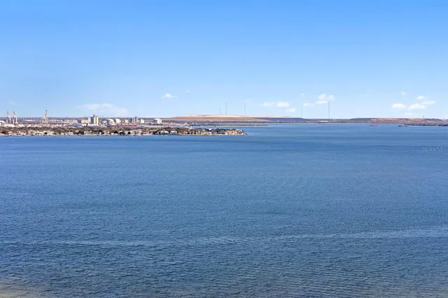 a kitchen with stainless steel appliances granite countertop a sink dishwasher a refrigerator and white cabinets with wooden floor