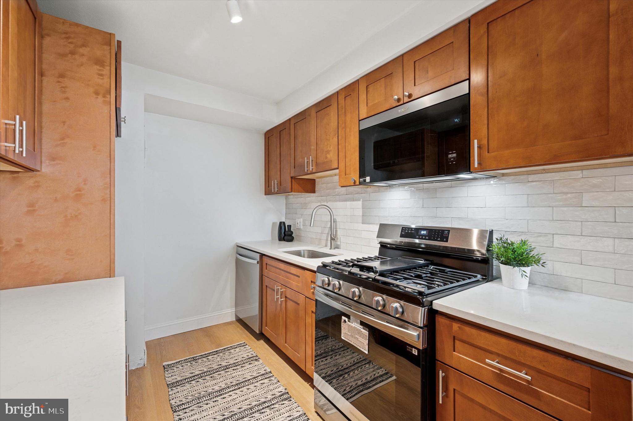 604 South Washington Square, Unit 1015 Philadelphia, PA 19106 - Photo 7 of 24 a kitchen with stainless steel appliances a sink a stove top oven a counter space and cabinets